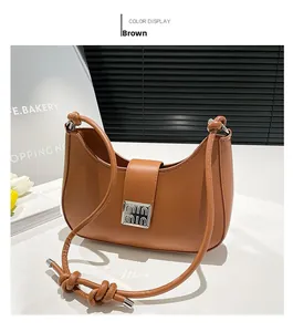 Detail of a brown hobo bag featuring a silver square buckle and leather knot shoulder strap
