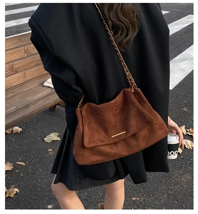 Vue arrière d'un sac bandoulière en daim marron avec chaîne dorée pour un style d'automne