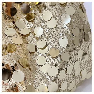 Macro detail of high-quality golden sequins on a luxury crossbody chain bag