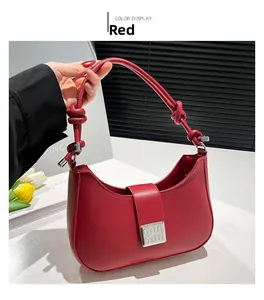 Detailed view of red leather shoulder bag with silver square clasp and knotted strap