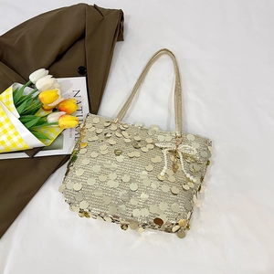 Golden sequin tote bag with pearl bow charm on white background with tulips