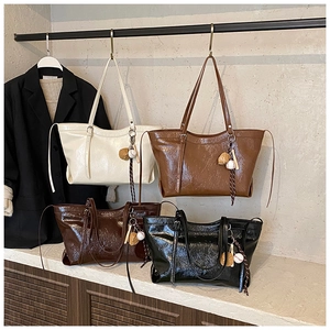 Detailed view of four colors of stylish tote bags with baseball charms and textured finish