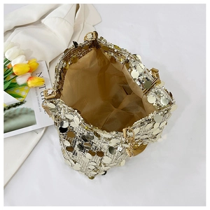 Close-up of golden sequin handbag showing textured sparkle surface and soft inner lining