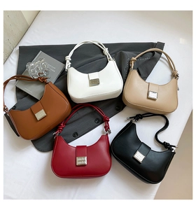 Flat lay of solid color minimalist crescent underarm bags with striped silver metal buckles