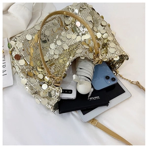 Spacious interior of gold sequin crossbody bag holding tablet, phone and umbrella