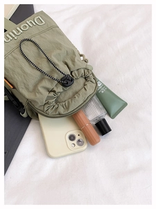 Interior view of the green nylon drawstring bag showing spacious storage for essentials