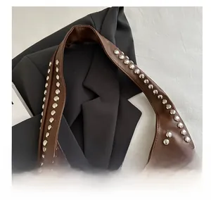 Detail shot of a brown leather bag featuring stylish silver metal rivet studs decoration