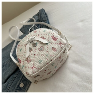Detail of white mini backpack with pink bear prints, 3D bow and gold metal heart charm