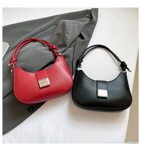 Close-up of red and black leather hobo bags featuring knotted straps and metal buckles