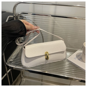 Detailed macro view of white crocodile pattern PU leather shoulder bag with gold metal buckle