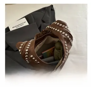 Macro detail of large capacity brown leather tote bag with silver rivets and daily items