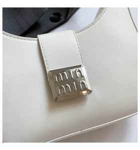 Detailed close-up of white leather handbag with rectangular silver buckle and fine stitching