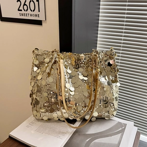 Golden sequin tote bag with disco style chain straps shown on a fashion magazine