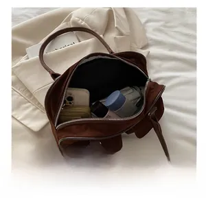 Spacious interior of dark brown suede shoulder bag showing storage for phone and wallet