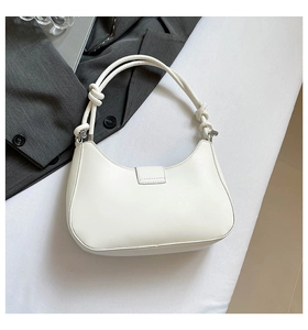 Detailed view of white half-moon hobo bag with unique knotted strap and silver hardware