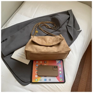 Brown suede crossbody tote with gold chain strap, shown with iPad for scale reference
