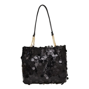 Fashionable black sequin tote bag with gold chain and leather handle on white background