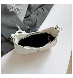 Internal view of a white crescent shoulder bag showing spacious lining and a zip pocket