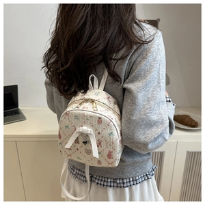 Détail du mini sac à dos blanc avec motifs nœuds roses et ours sur le mannequin