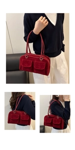Détail d'un sac sous le bras en velours bordeaux avec deux poches avant et lanière