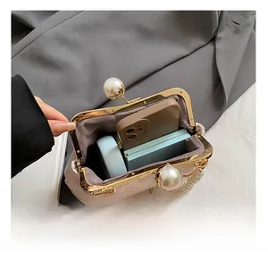 Detail view showing interior capacity of embroidered bag with pearl kiss lock and lining