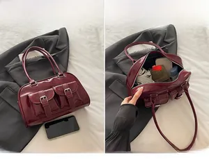 Macro view of burgundy patent leather bag showing double front pockets and spacious interior