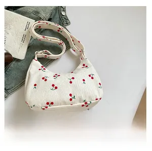 Dettaglio borsa a spalla in velluto a coste bianco crema con stampe di ciliegie rosse