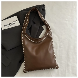 Detail of vintage dark brown leather hobo bag with silver metallic stud embellishments