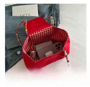 Internal view of large capacity red tote bag with red and white plaid lining detail