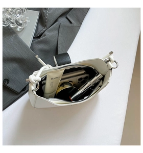 Interior view of white leather shoulder bag showing spacious storage for makeup and phone