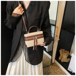 Detail view of contrast stitching handbag with double zipper and brown leather trim