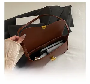 Interior view showing capacity of brown leather baguette bag with gold metal buckle