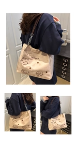 Detail of canvas tote bag with cartoon cat embroidery and brown leather chain straps