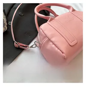 Detailed close-up of pink Boston bag showing PU leather texture and embossed logo