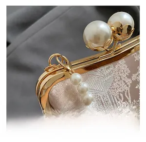 Detail of pink floral jacquard fabric evening bag with pearl clasp and metal hook