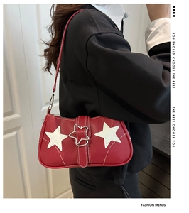 Detail view of red retro underarm bag with white star patches and star-shaped buckle