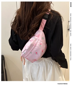 Detailed view of pink floral waist bag with bow patterns and durable nylon strap