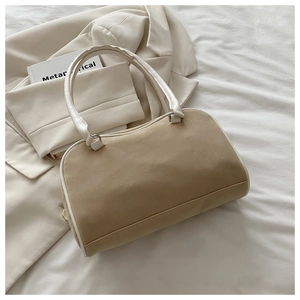 Détail d'un sac Boston bicolore beige et blanc avec des poignées en cuir lisse