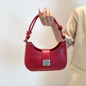 Red hobo handbag with a knotted top handle and silver buckle on a clean white background