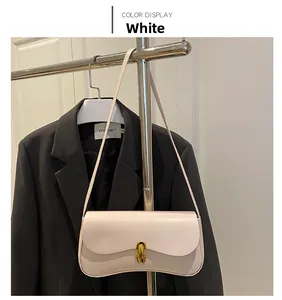 Close-up of creamy white PU leather underarm bag with gold oval twist lock closure