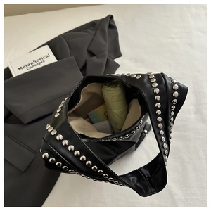 Detail of black tote bag with silver studs showing large interior capacity for daily items