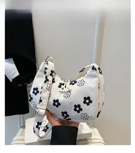 Dettaglio borsa hobo in velluto bianco con fiori neri e tracolla regolabile