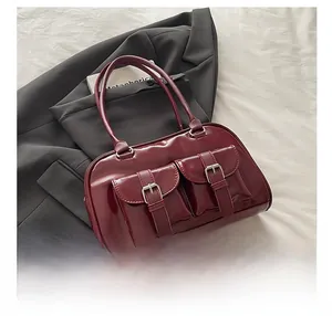 Detail of burgundy retro bowling handbag with dual front pockets and glossy finish