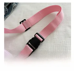 Detail of pink woven strap with durable black plastic buckle on a crossbody dumpling bag