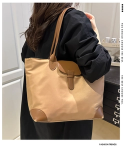 Dettaglio della borsa tote in nylon kaki con finiture in pelle marrone e angoli rinforzati