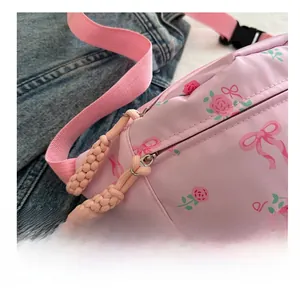 Detailed close-up of smooth pink metal zipper on floral nylon crossbody bag