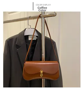 Detail of coffee brown leather shoulder bag featuring a gold rectangular metal clasp