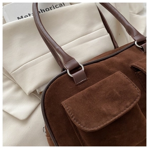 Vue détaillée du sac cabas en daim marron foncé avec deux poches et boucles argentées