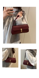 Detail view of burgundy leather underarm bag with golden metal clasp and lychee texture