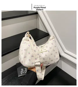 Dettaglio della borsa a spalla in velluto bianco con motivi floreali viola e cerniera